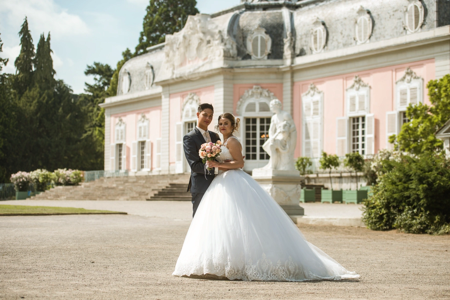 Brautpaar vor einem rosa Schloss
